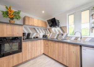 a kitchen with wooden cabinets and a sink at Nou Kontan vwe zot in Abbecourt