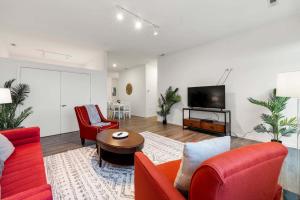 ein Wohnzimmer mit roten Möbeln und einem Flachbild-TV in der Unterkunft Spacious 3BR Urban Getaway w Gym in Chicago + 27 Fotos