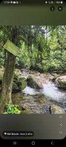 De la rosa y el canto de los pájaros في باراتي: شاشة تلفزيون تعرض جدولاً مائياً في غابة +3 صور