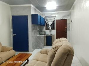 Top Crew Cottage Kempton Park في كيمبتون بارك: غرفة معيشة مع أريكة وباب أزرق