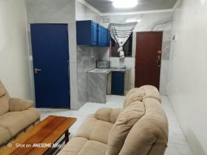Top Crew Cottage Kempton Park في كيمبتون بارك: غرفة معيشة مع أريكة وطاولة ومطبخ