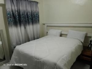 Top Crew Cottage Kempton Park في كيمبتون بارك: غرفة نوم بسرير أبيض ونافذة