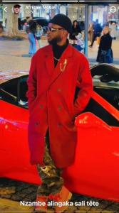 een man in een rood pak staat naast een rode auto bij Fuanani in Montgeron