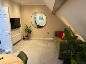 a living room with a couch and a mirror at Coastal Nest in Margate