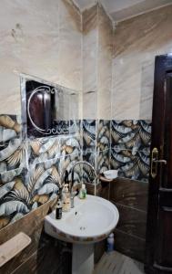un bagno con un lavandino e una parete con piastrelle a tema animale di Shali Castle Apartment a Siwa