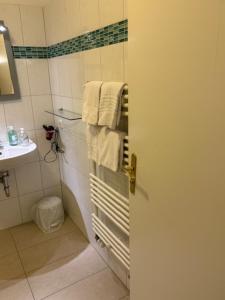 a bathroom with a shower and a sink and towels at Attika Hotel in Halstenbek