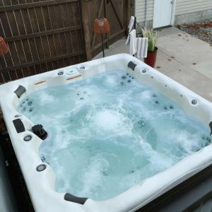 Pine & Paddle Getaway Game Room Hot Tub Pool في مسكيغون: حوض جاكوزي ساخن في الفناء الخلفي