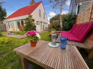 a picnic table with a pink chair and flowers on it at Casa Divera in Noordwijkerhout