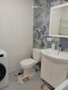 un bagno bianco con un water e un lavandino di Serenity a Ternopilʼ