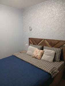 un letto con cuscini sopra di Serenity a Ternopilʼ