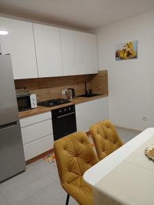 una cucina con mobili bianchi e un forno a piano cottura di Serenity a Ternopilʼ