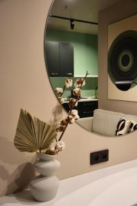 a room with a mirror and a vase with a plant at STRYH21 by APT21 in Wisła