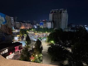 a view of a city at night at The Art Ceiling Loft at Main Square in Prishtinë