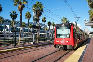 a red train traveling down the tracks near palm trees at Courtyard by Marriott San Diego Downtown Little Italy in San Diego