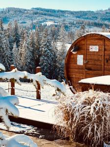 a wooden cabin in the snow with snow covered trees at Witowiańskie Domki z prywatnym jacuzzi i kominkiem in Dzianisz