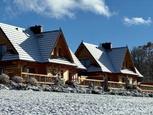 a log cabin with snow on its roof at Witowiańskie Domki z prywatnym jacuzzi i kominkiem in Dzianisz