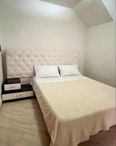 a bedroom with a large bed with a white headboard at Fami Hotel Luz de Luna in Jardin
