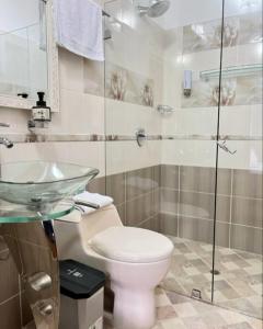 a bathroom with a toilet and a glass shower at Fami Hotel Luz de Luna in Jardin +5 photos