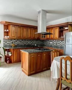a kitchen with wooden cabinets and a stove top oven at Fami Hotel Luz de Luna in Jardin