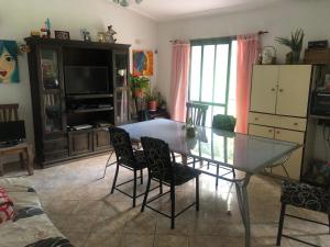 a living room with a glass table and chairs at Carcano in Villa Carlos Paz