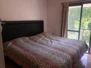 a bed in a bedroom with a window at Carcano in Villa Carlos Paz