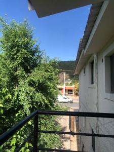 a balcony of a house with a tree and a car at Carcano in Villa Carlos Paz