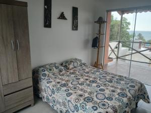 a bedroom with a bed and a view of the ocean at Casa de praia Laranja a beira-mar in Ilhéus