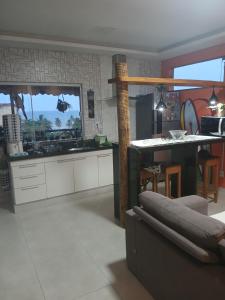 a kitchen with a couch and a table in a room at Casa de praia Laranja a beira-mar in Ilhéus