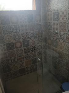 a bathroom with a shower with a glass door at Casa de praia Laranja a beira-mar in Ilhéus +4 photos