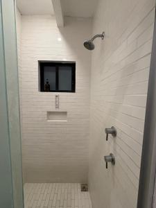 a bathroom with a shower with a mirror and a window at NIDO Hotel in San Miguel de Allende