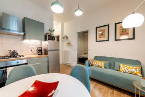 a kitchen and a living room with a couch and a table at APARTMENT BONCIARI PERUGIA Comodo e moderno bilocale con posto auto gratuito e self check in in Perugia