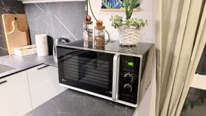 een magnetron bovenop een aanrecht bij Pomodoro House - Luminoso appartamento vicino Linate, Sky, Fabrique, Arena Santa Giulia in Milaan