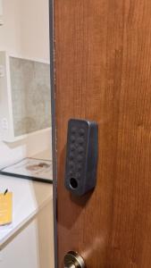 een afsluiting van een houten deur met een slot bij Pomodoro House - Luminoso appartamento vicino Linate, Sky, Fabrique, Arena Santa Giulia in Milaan