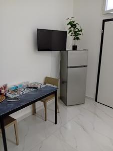 Il Don Giovanni Room في بارليتا: غرفة طعام مع طاولة وثلاجة