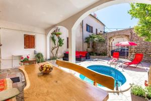 Villa mit einem Pool, einem Tisch und Stühlen in der Unterkunft Apartments Samia in Medulin