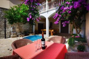 einen roten Tisch mit einer Flasche Wein drauf. in der Unterkunft Apartments Samia in Medulin