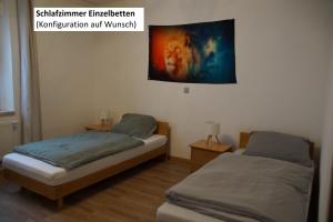 ヘルツォーゲンアウラッハにあるFortl's Apartmentの壁に絵が飾られた部屋にベッドが2つある