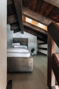 ein Schlafzimmer mit einem Bett im Loft mit Holzdecken in der Unterkunft Casa Laret 6-12 in Laax-Murschetg + 20 Fotos