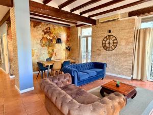 ein Wohnzimmer mit einem blauen Sofa und einem Tisch in der Unterkunft Teixidors de Palomar - PalomarGroup in Valencia