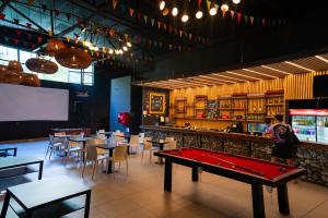 a ping pong table in a restaurant with tables and chairs at The Hostel Santiago in Santiago