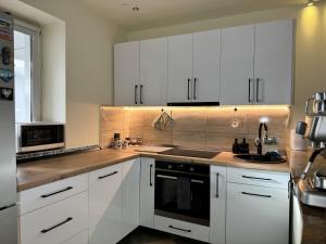 a kitchen with white cabinets and a sink at Gusterita Hideaway in Sibiu