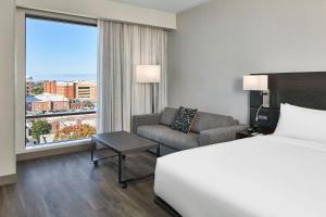 a hotel room with a bed and a couch and a window at AC Hotel by Marriott Auburn in Auburn +76 photos