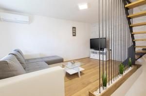 een woonkamer met een bank en een tv bij House Bernarda in Medulin