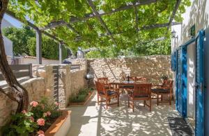 een terras met een tafel en stoelen onder een pergola bij House Bernarda in Medulin