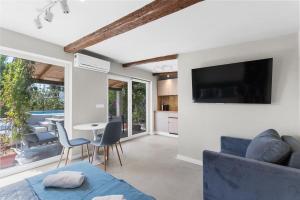 un soggiorno con un divano blu e una TV di Villa Alis a Karpinjan