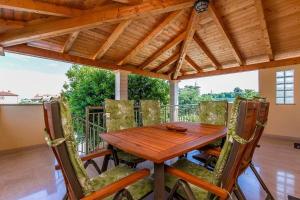 a wooden table and chairs on a balcony at Villa Cera in Vodnjan