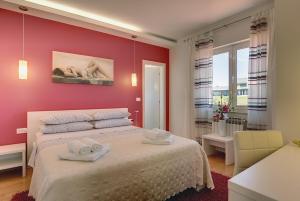 een rode slaapkamer met een bed met handdoeken erop bij Villa Allegra in Kanfanar +33 foto's