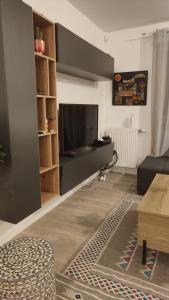 a living room with a flat screen tv and a couch at T3 lumineux avec balcon, proche des transports in La Celle-sous-Gouzon