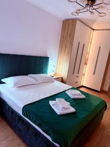 una camera da letto con un letto con due asciugamani sopra di Harmony Suite a Baia Mare