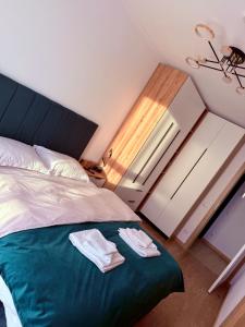 una camera da letto con un letto con due asciugamani sopra di Harmony Suite a Baia Mare
